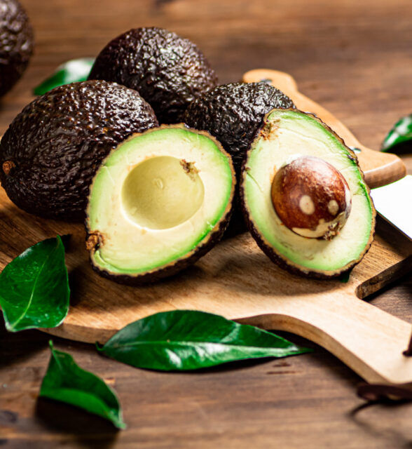 Halves of fresh avocado on a cutting board. On a wooden background. High quality photo