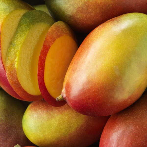 whole and sliced mangoes, close up shot